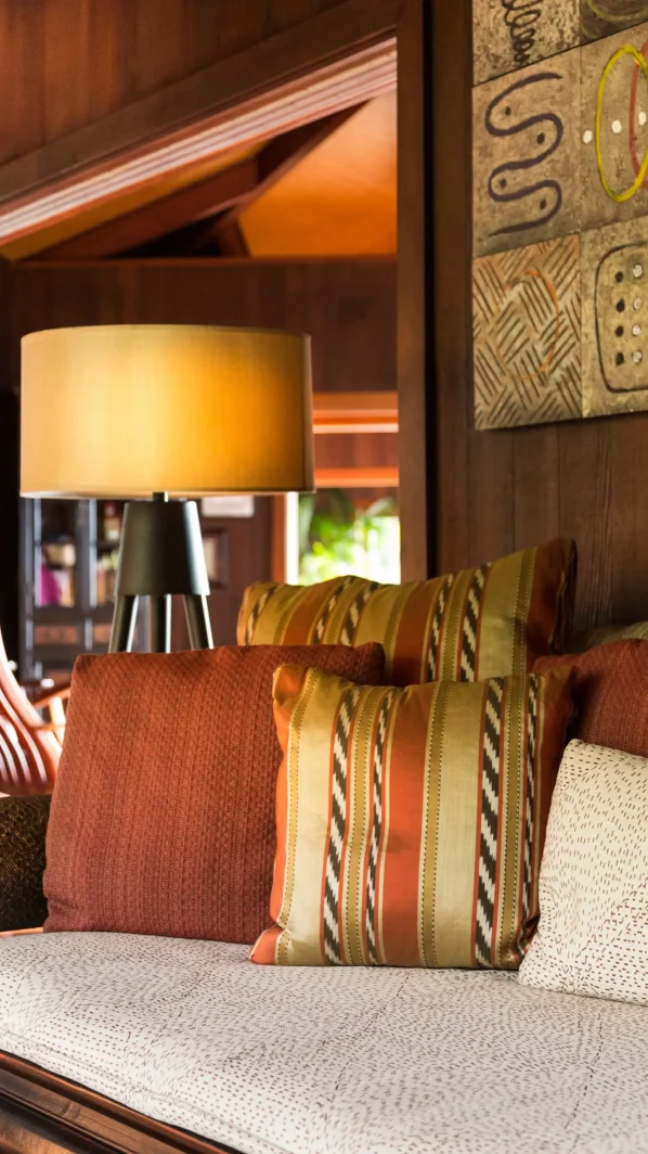 Throw pillows in warm earth tones on traditional daybed in Hawaii common room