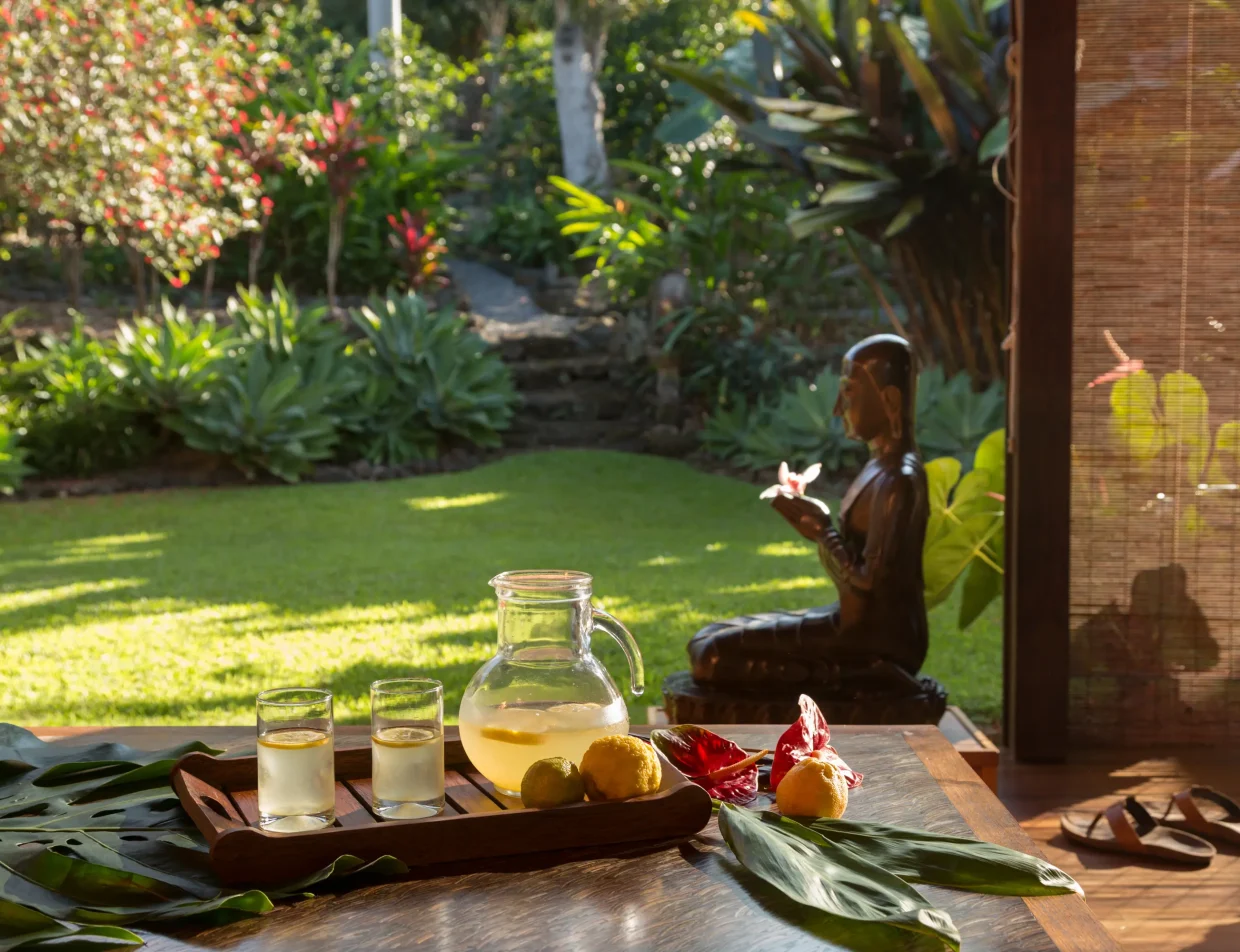 Garden-facing table with lemonade, citrus, and tropical flowers at Big Island retreat