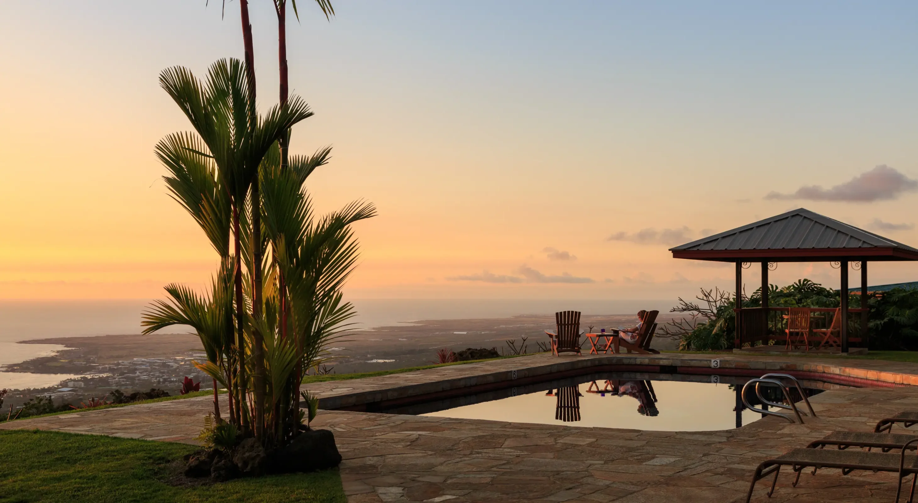 Sunset views over the Kona coastline from the poolside gazebo at a boutique Big Island inn