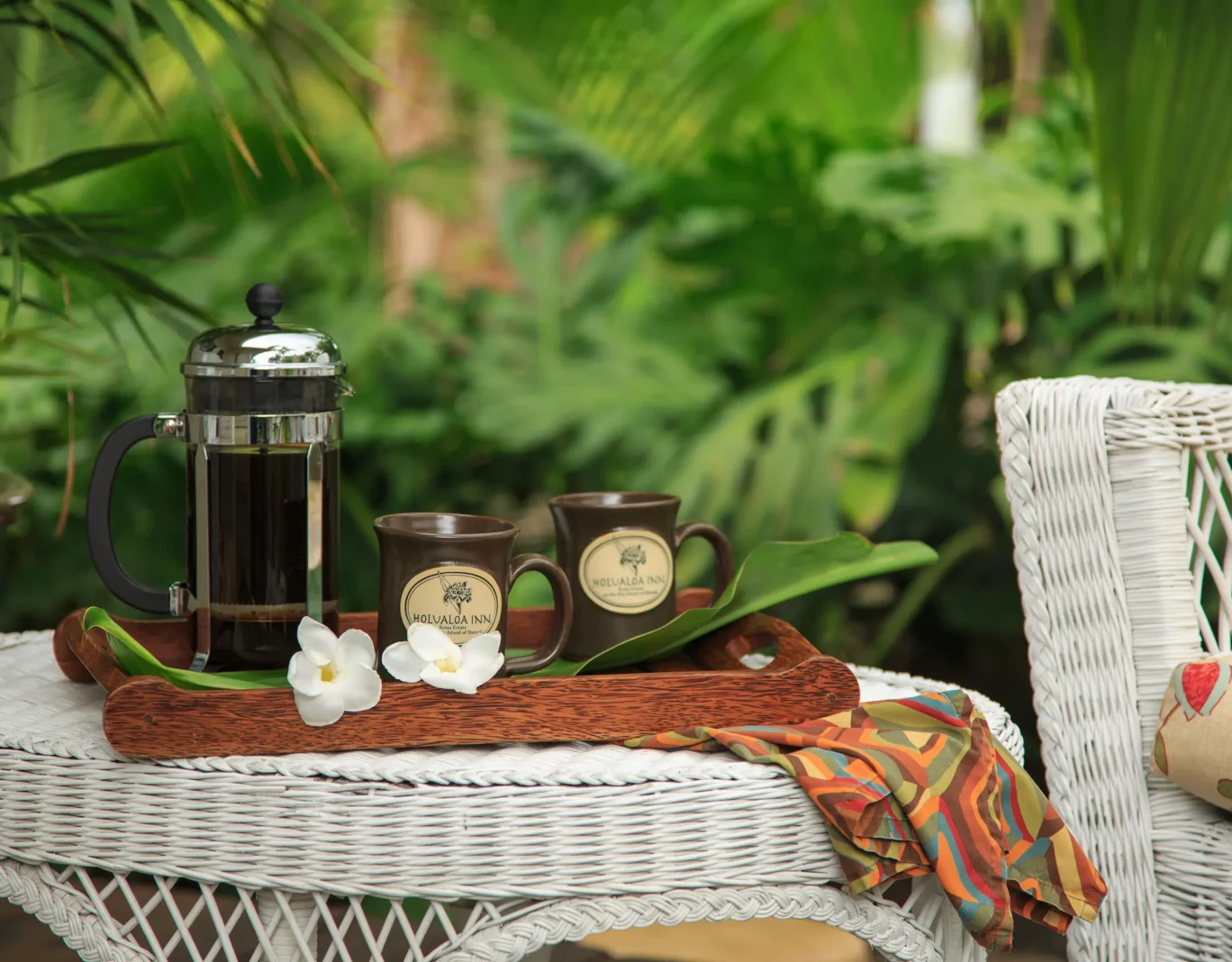Holualoa Inn French press coffee with custom mugs on outdoor wicker table - Kona Bed and Breakfast